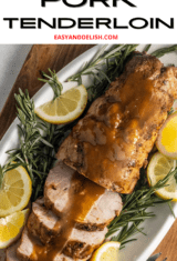 close up of roasted pork tenderloin garnished with lemon and rosemary.