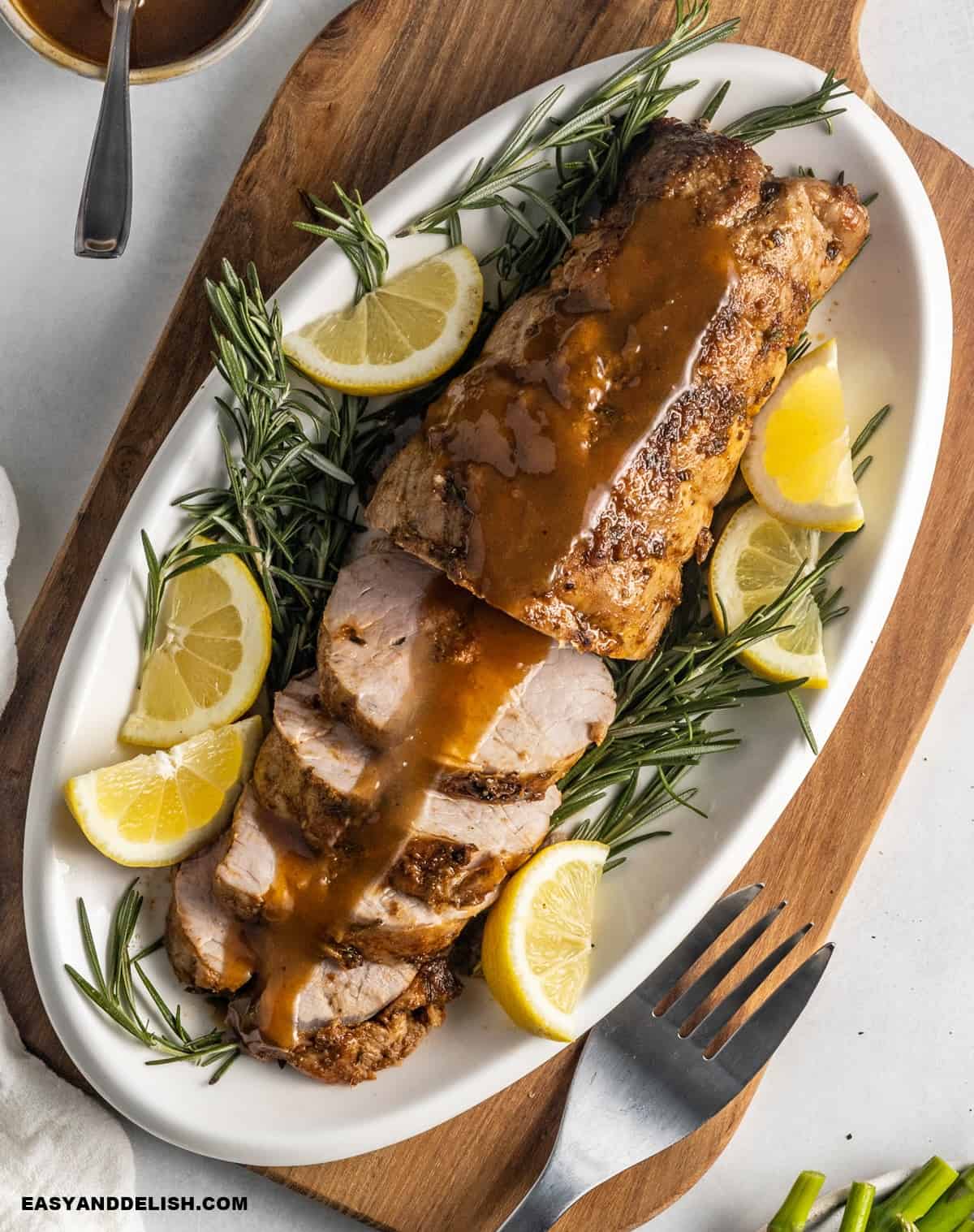 Roasted Smithfield pork tenderloin with wine sauce and fresh garnishes.