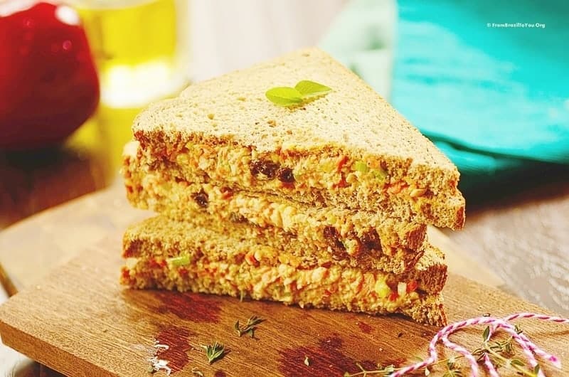 A stack of chicken salad sandwiches on top of a cutting board.