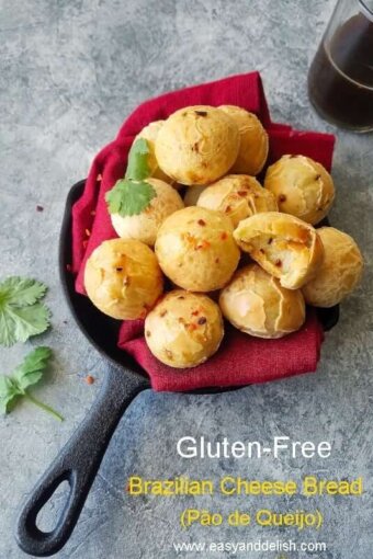 A close up of a bunch of Brazilian cheese bread ina bowl with a cup of coffee on the side