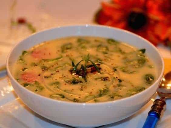 serving Portuguese kale soup in a bowl