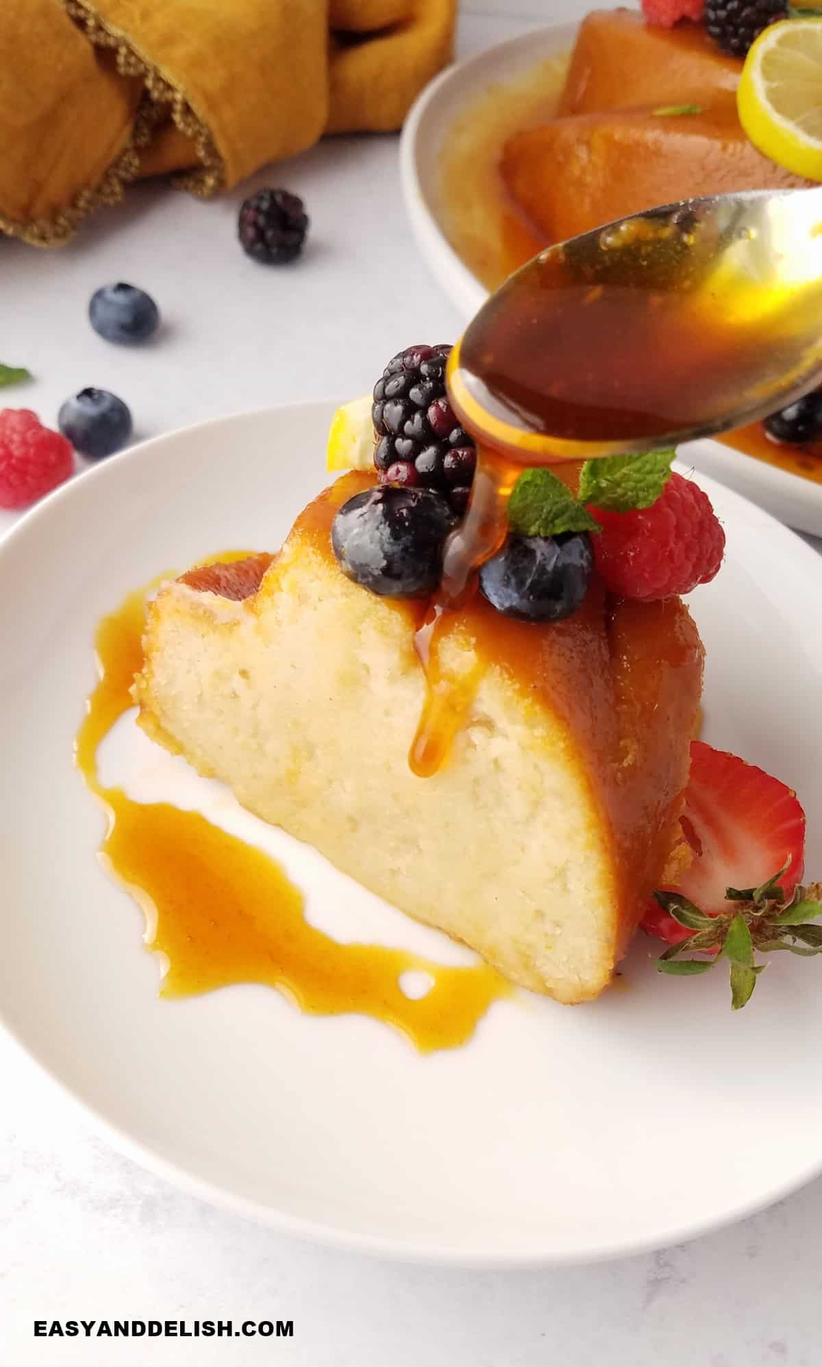 a slice of easy sourdough bread pudding with caramel sauce dripped over with a spoon. 