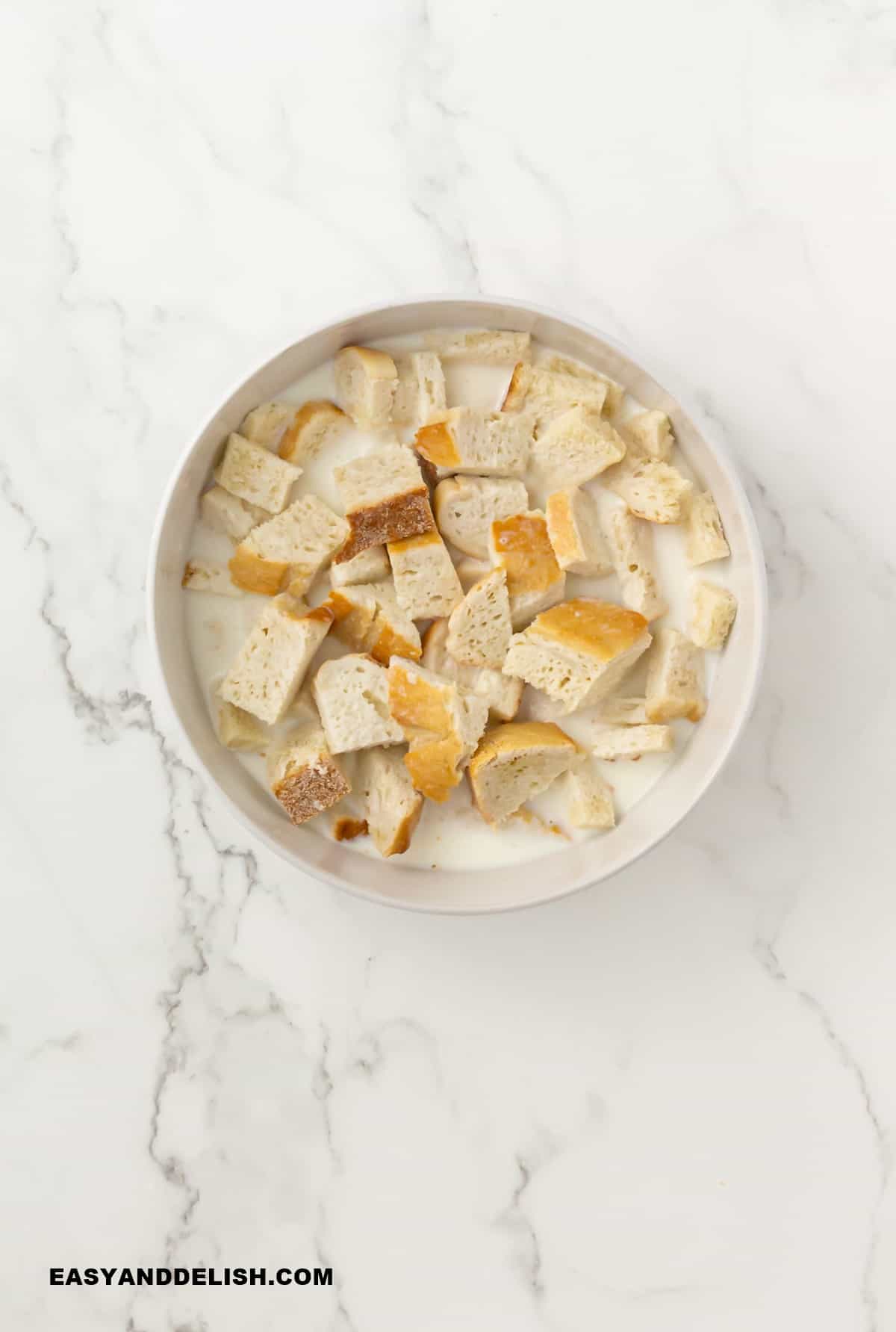 a bowl with bread soaked in warm milk.