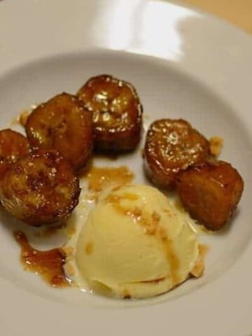 caramelized bananas with a scoop of vanilla ice cream on a plate