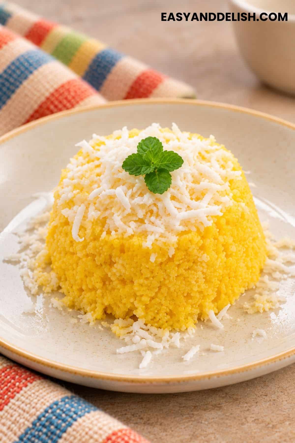 Cuscuz de Milho topped with coconut flakes and mint.