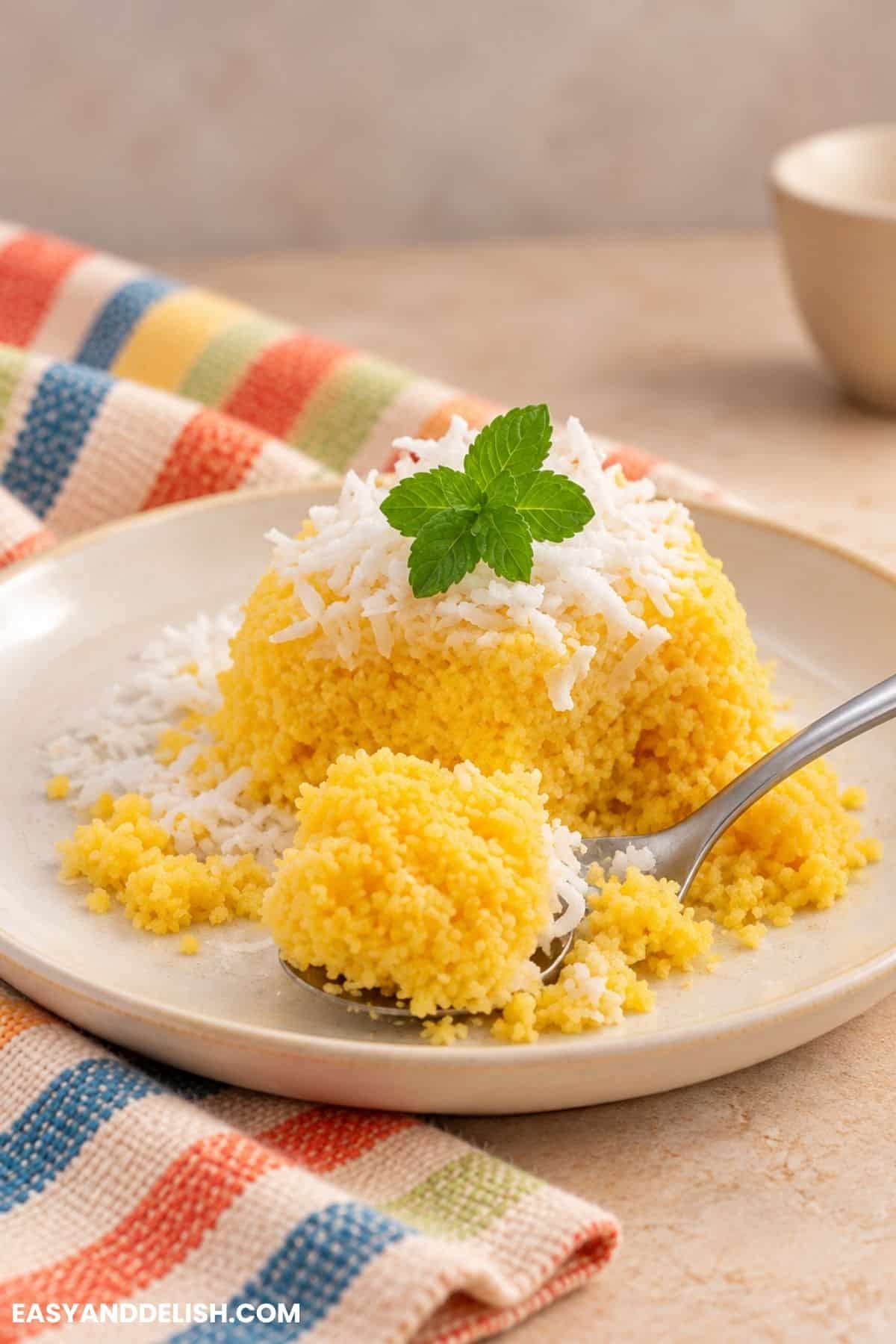 Cuscuz de Milho topped with coconut flakes and mint.