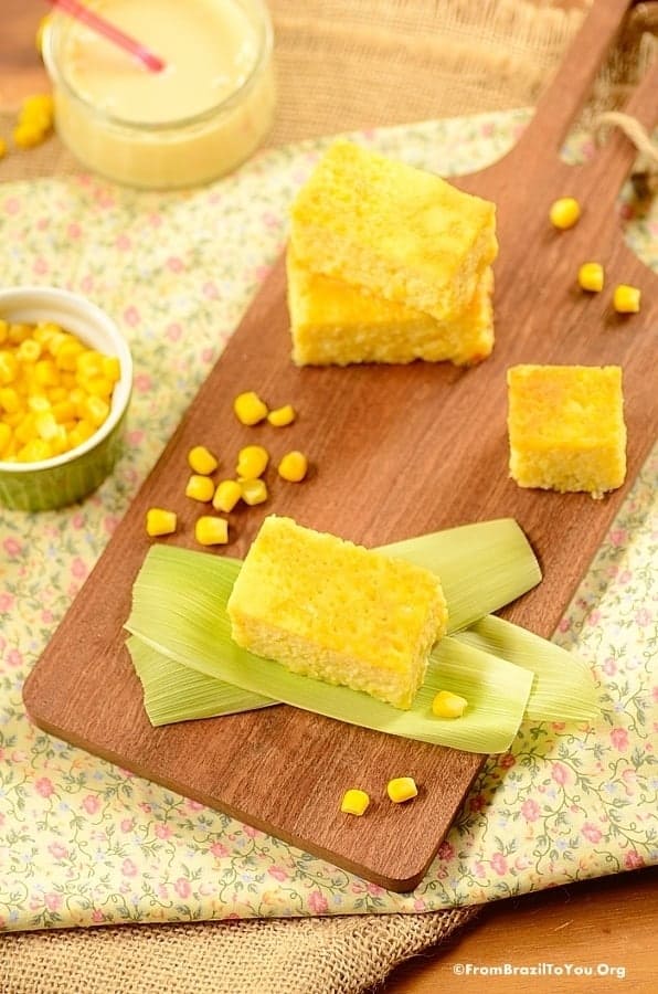 Yellow pamonha de forno sticky corn cakes on a wood cutting oard