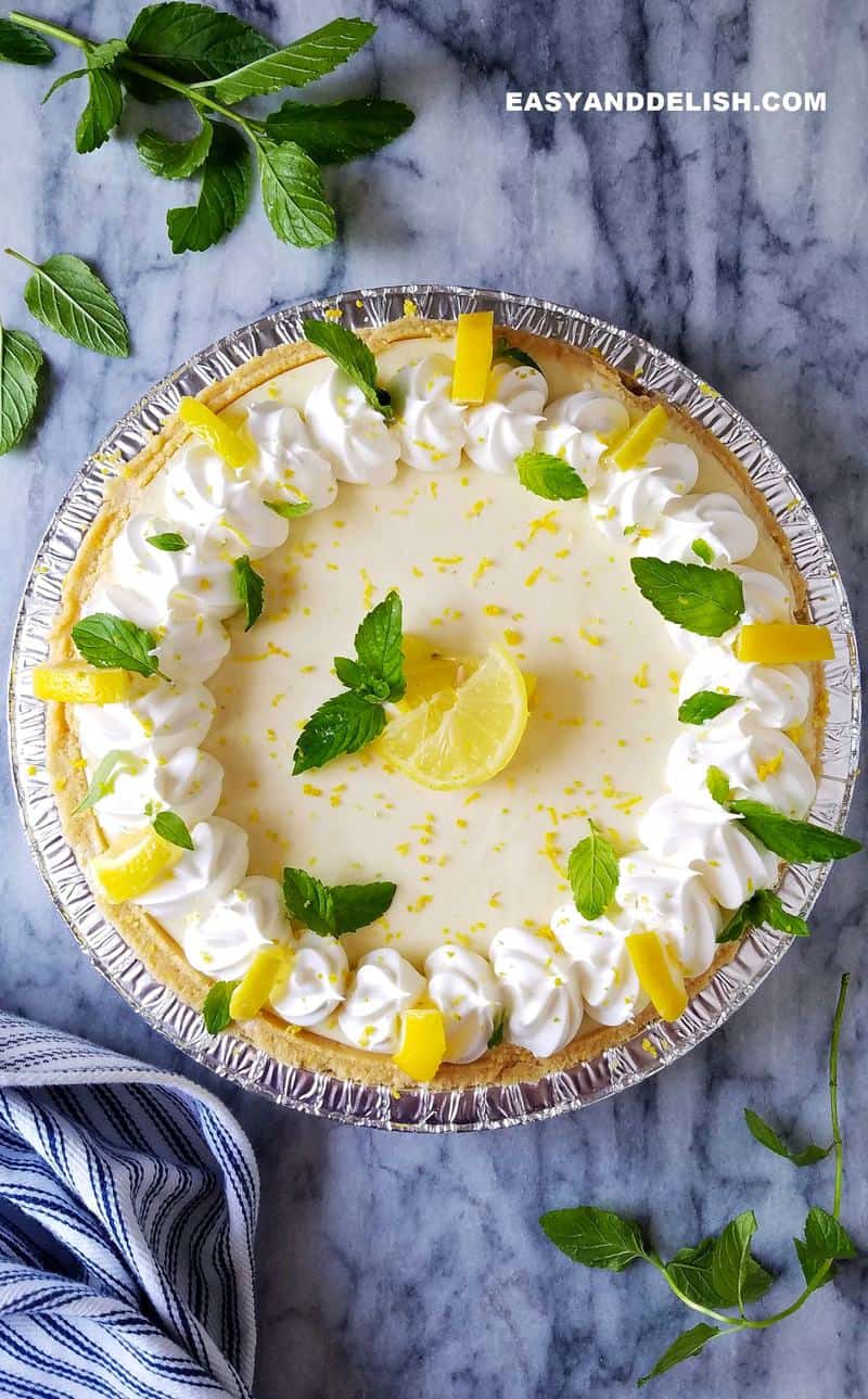 a whole lemon icebox pie with garnishes around 