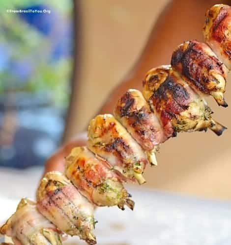 A skewer of grilled chicken thighs wrapped in bacon
