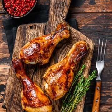 grilled chicken drumsticks over a cutting board with herbs