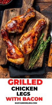 close up of grilled chicken drumsticks with herbs and spices on a cutting board