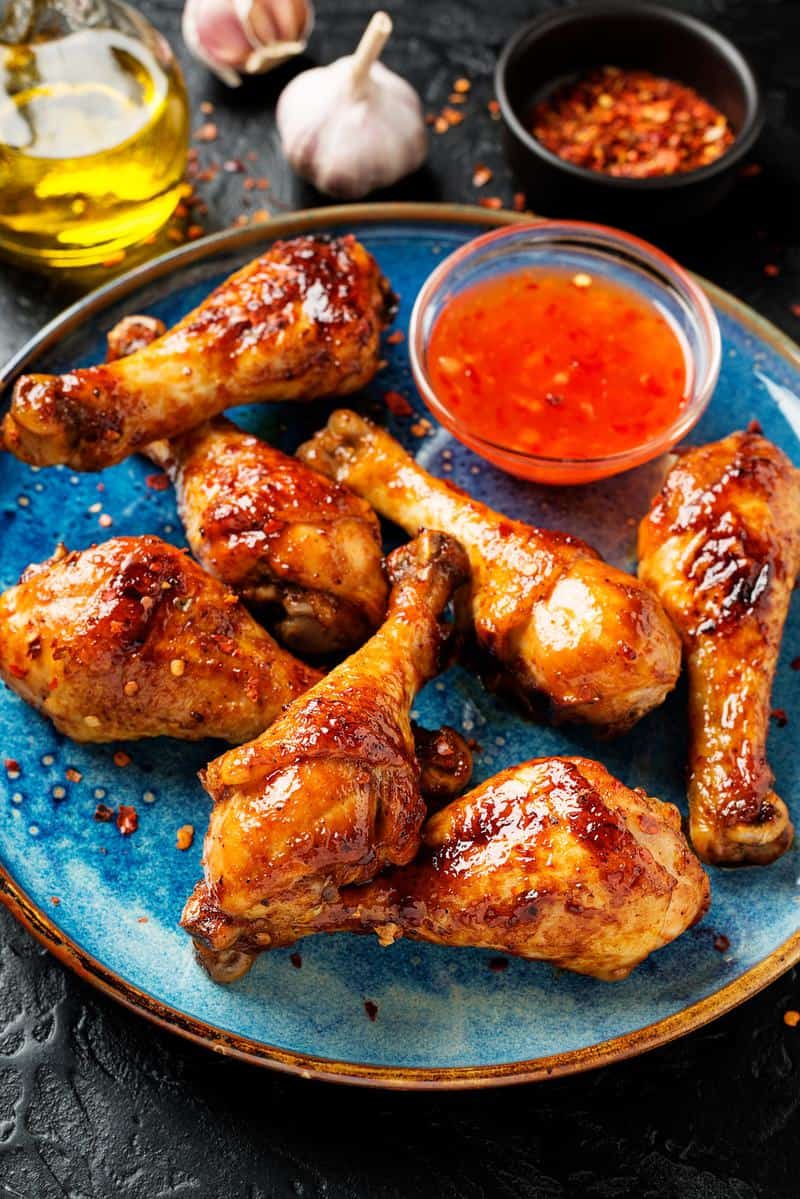 grilled chicken legs in a plate with sauce