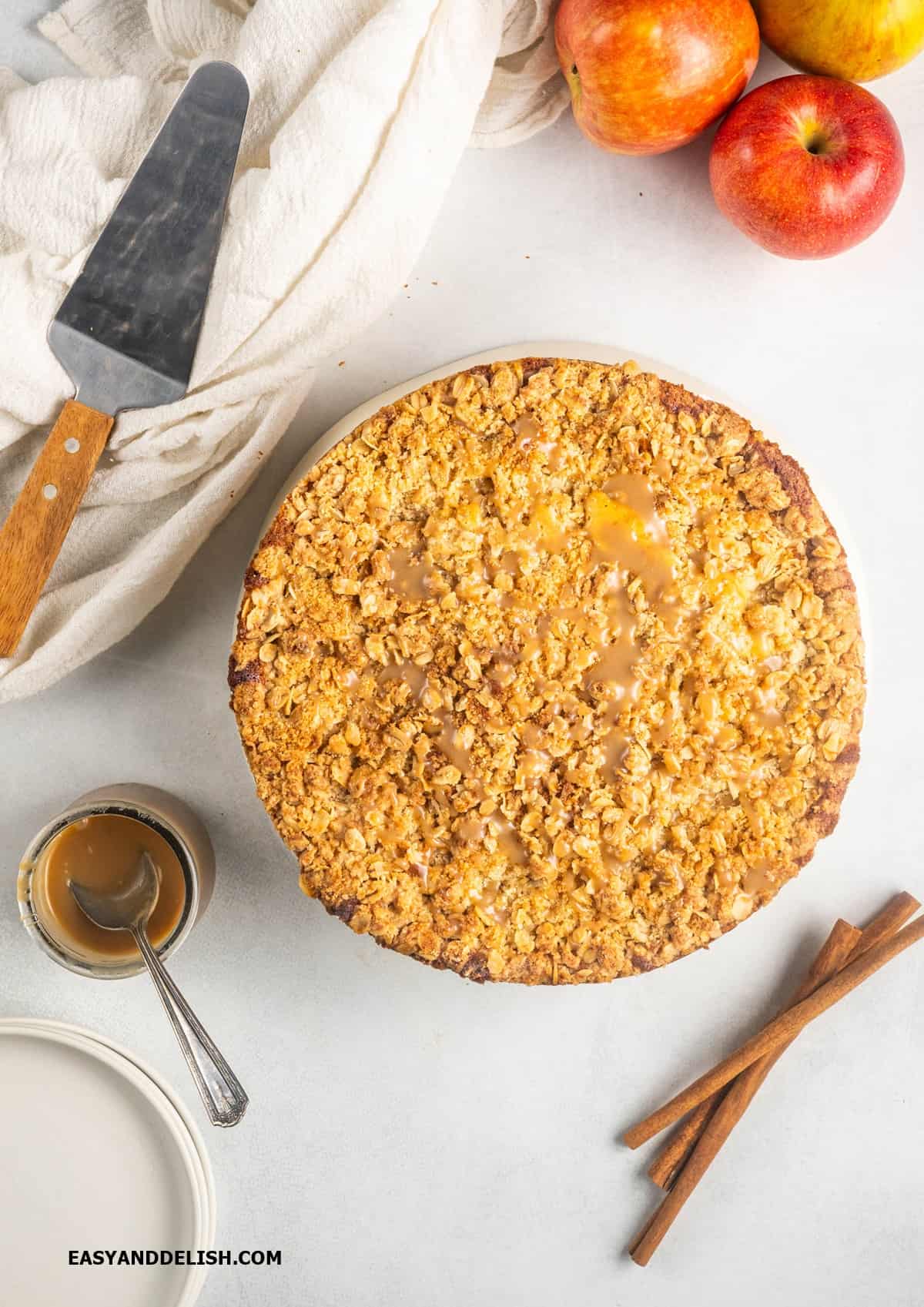 a whole apple streusel cake with caramel on top. 
