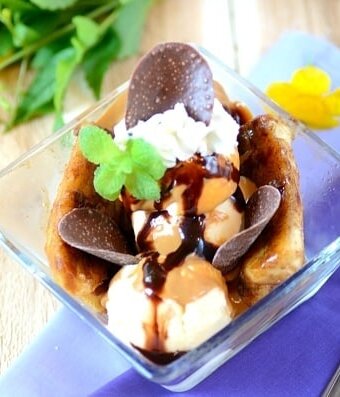 Banana split with chocolate sauce in a glass dish