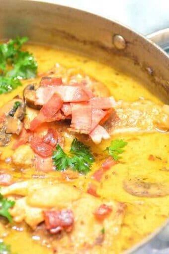 A skillet full of beer braised chicken with sauce