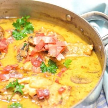 A skillet full of beer braised chicken with sauce
