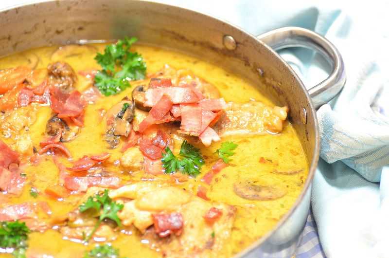 A skillet full of beer braised chicken with sauce