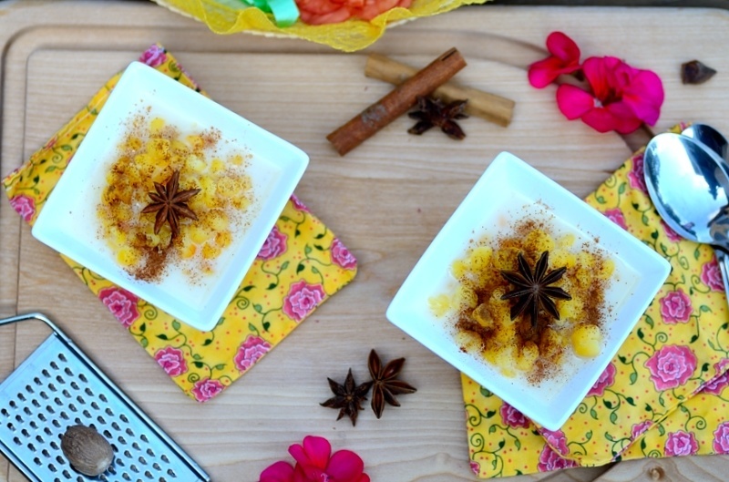bowls of corn pudding on a table with garnishes on the sides