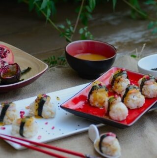 A plate of sushi on a table with red chopsticks