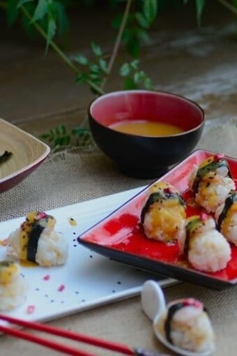 A plate of sushi on a table with red chopsticks