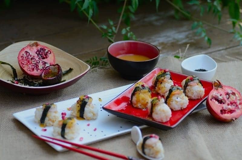 A plate of sushi on a table with red chopsticks