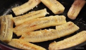 Pan-frying the bananas banana slices being cooked in a pan