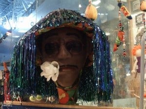 A statue of a person standing in front of a store display for Carnival