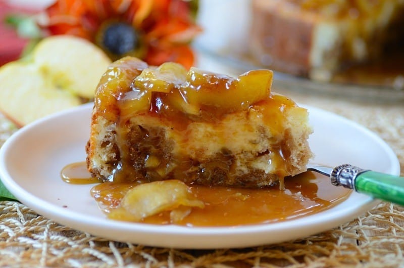 A plate of cheesecake with apple and caramel topping
