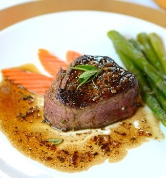 A plate of filet mignon with carrots and asparagus