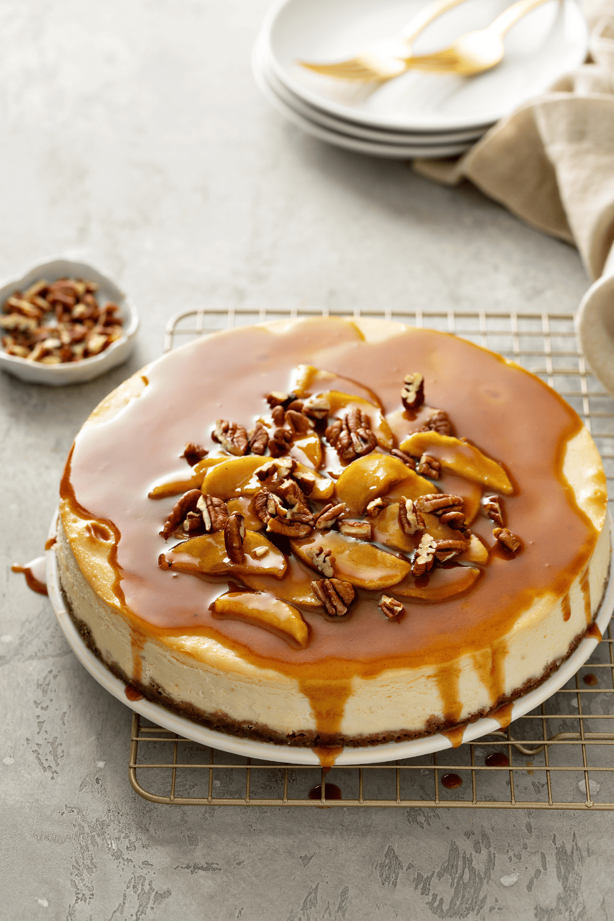 sugar-free caramel apple pecan cheesecake with garnishes around it.