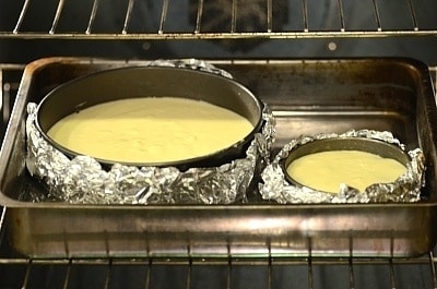 A close up of metal pans on a stove, with Almond Cherry Cheesecake