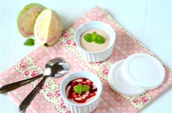 Dois recipientes de mousse de goiaba em uma mesa com duas colheres