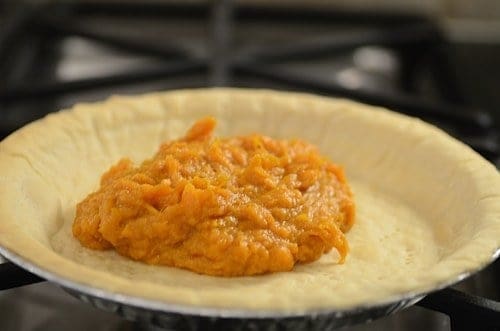 pie crust is filled with sweet potato pie filling