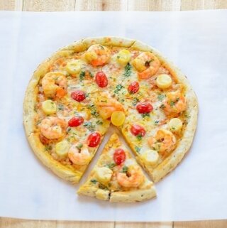 A sliced shrimp pizza sitting on top of a table
