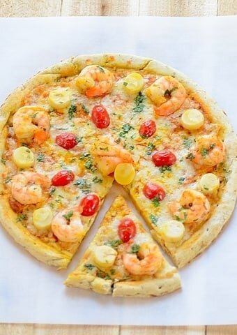 A sliced shrimp pizza sitting on top of a table