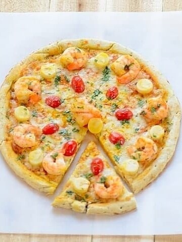 A sliced shrimp pizza sitting on top of a table