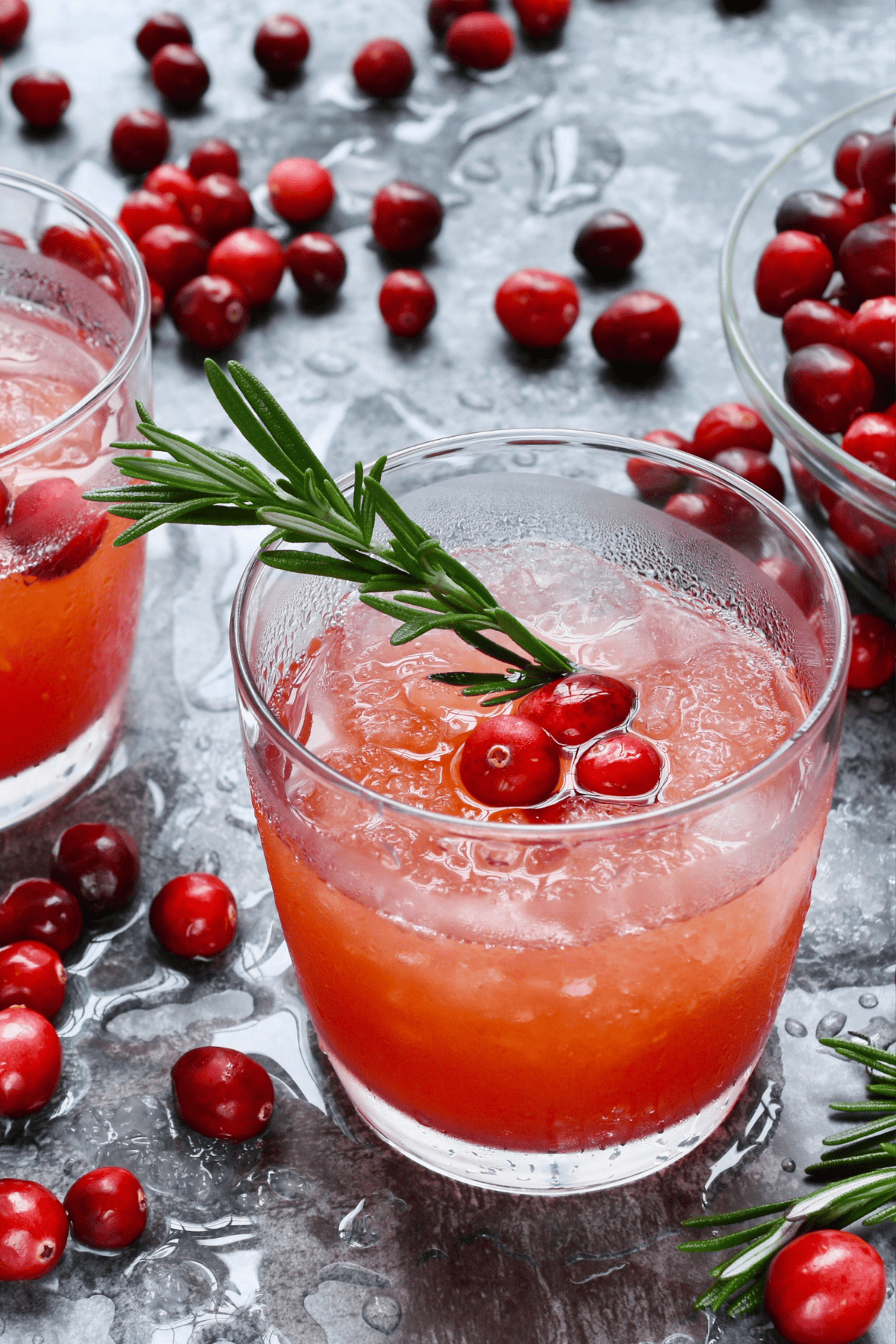 a glass half filled with sparkling orange cranberry cocktail.