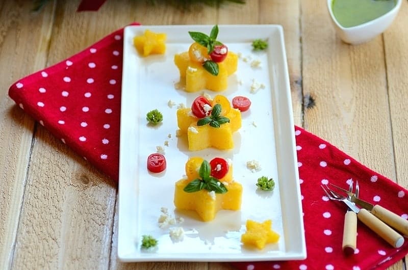 Christmas fried polenta cakes with fresh toppings in a platter. 