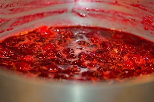 cranberry sauce being cooked in a pan