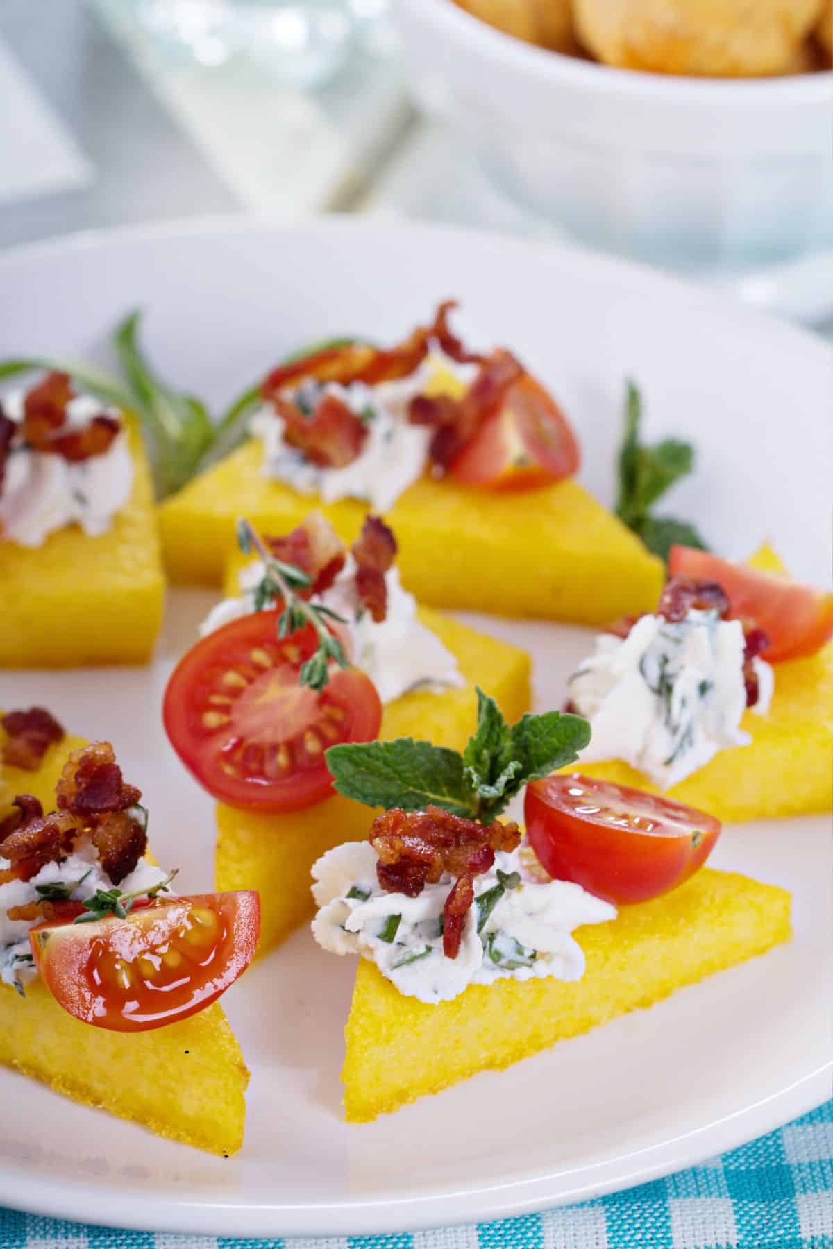 Fried polenta cakes with Italian toppings in a plate.