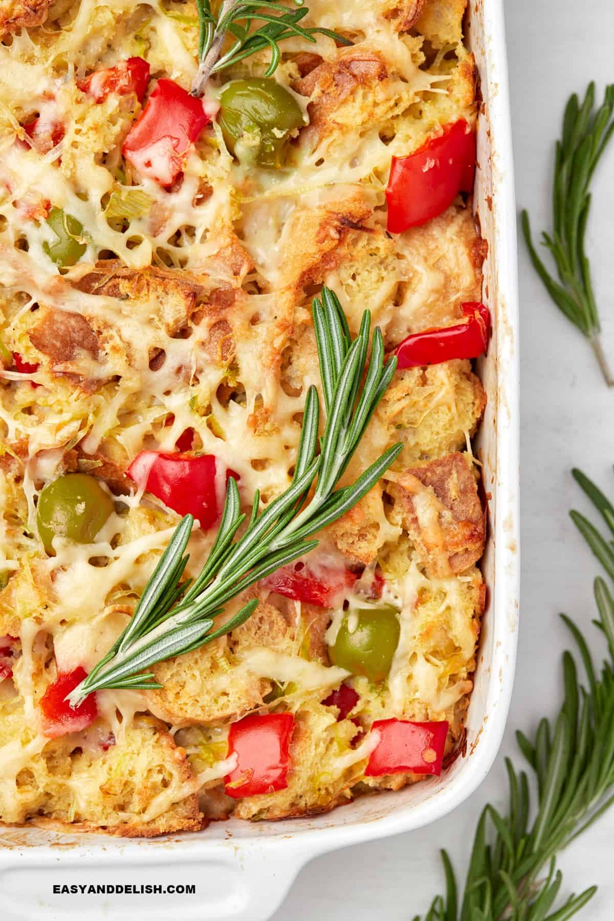 half of the savory bread pudding in a baking dish.