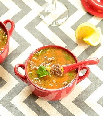 sopa de lentilhas em tigelas com bandinhas de limão ao lado