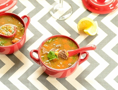 sopa de lentilhas em tigelas com bandinhas de limão ao lado