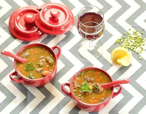 Lentil and Beef Soup served in bowls with a glass of wine on the side