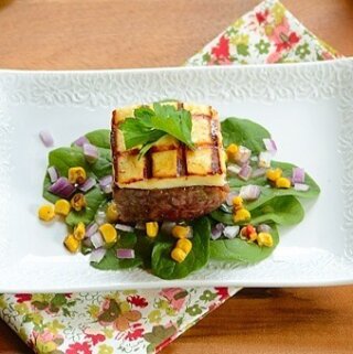 A square of carne de sol beef and cheese on a white plate