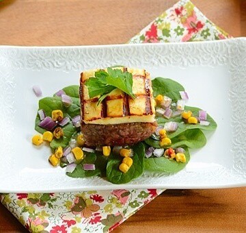 A square of carne de sol beef and cheese on a white  plate