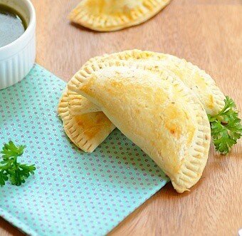 pizza empanadas on a table with sauce on the side