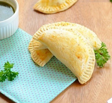 pizza empanadas on a table with sauce on the side