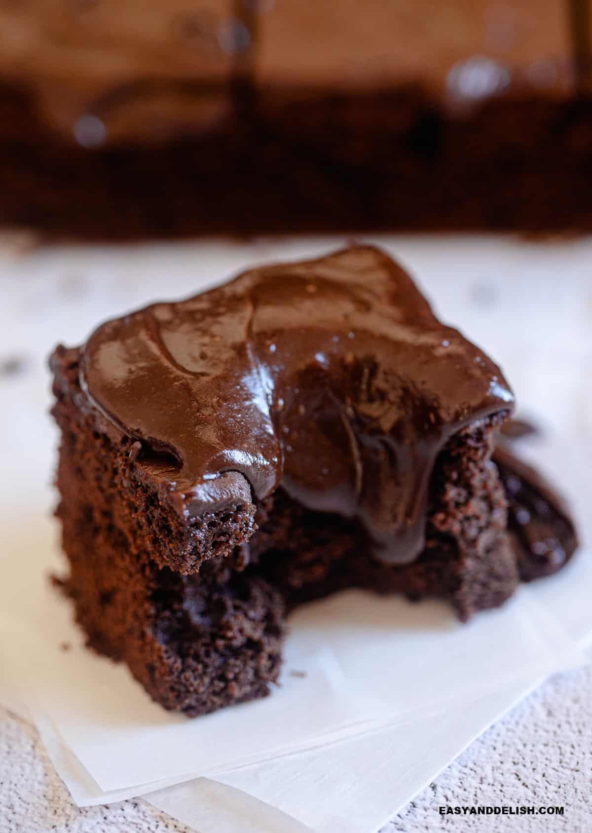 a slice of bitten baked good over parchment paper