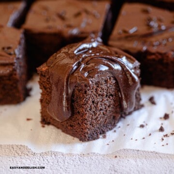 close up of a slice of dairy-free chocolate cake over a parchment paper